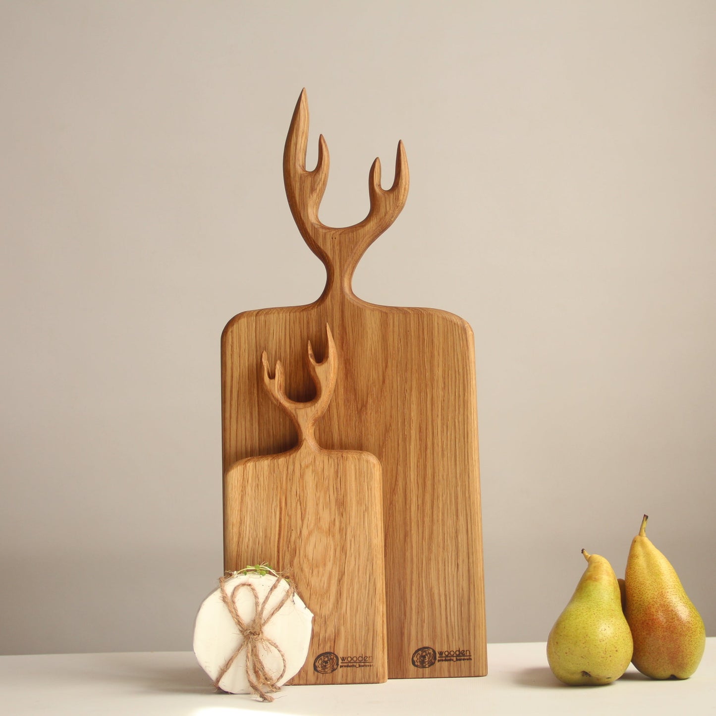 Wooden cutting board with deer head design on a neutral background