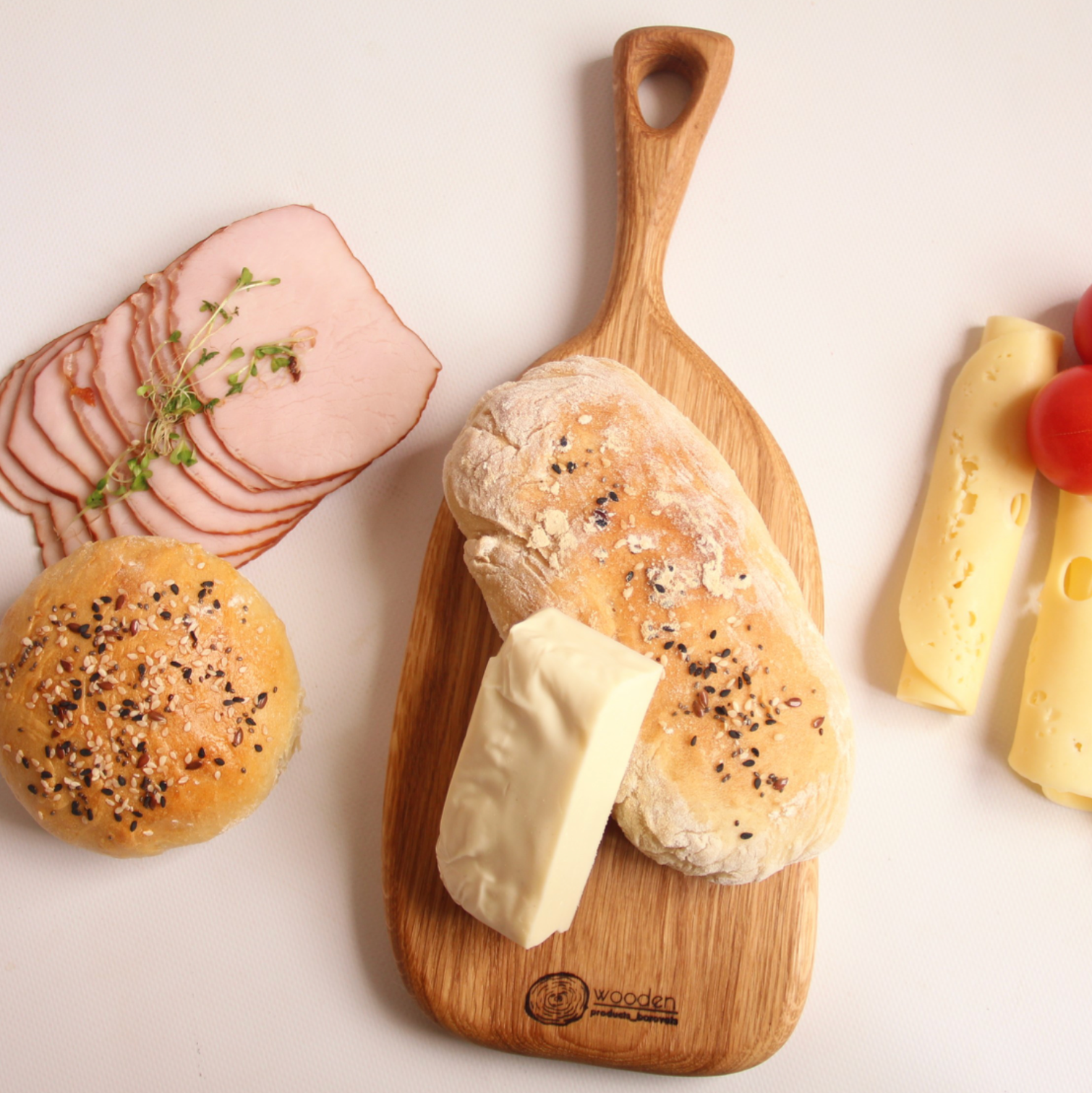 Hand placing snacks on an oak serving board for a festive holiday table